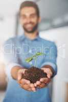 Taking responsibility for the future. an unrecognizable young businessman holding a seedling in his cupped hands.