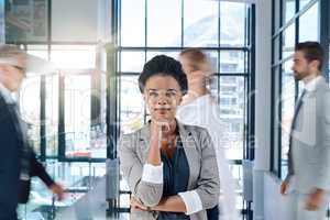 Shes got big dreams for the business. a young and confident businesswoman standing, thinking and smiling in the office.