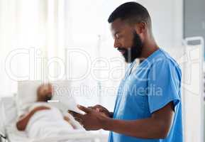Black doctor using a digital tablet while working with sick patients at a hospital, serious and thinking. African American health care worker using online organizer or planner to keep track of task