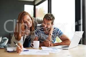 They enjoy doing the household budget. an affectionate young couple working on their household budget.