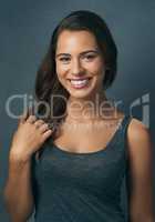 Happiness comes naturally to her. Studio shot of a beautiful young woman smiling against a blue background.