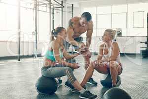 We could definitely incorporate this tutorial in our workout routine. a group of young people using a digital tablet at the gym.