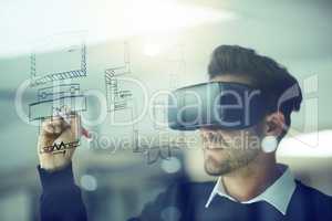 Build your own reality. a businessman wearing a VR headset while drawing on a glass wall in an office.