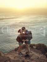 Kisses on the summit. High angle shot of an affectionate young couple kissing on a mountaintop.