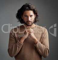 I take my spiritually very seriously. Studio shot of a handsome young man praying against a gray background.