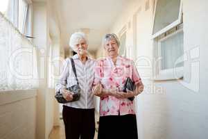 Life is better with a friend by your side. Portrait of two happy elderly women carrying their bags and getting ready to go out.