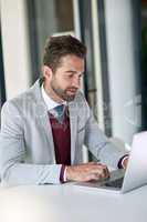 The number one guy to get it done. a businessman using a laptop at his office desk.