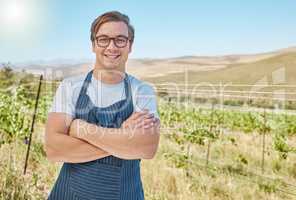 Vineyard and happy farmer man in the countryside with smile at a farm in nature in summer. Health, agriculture and success portrait of a young worker on a field in sustainability on a sunny day.