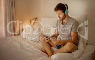 Headphones, digital tablet and in bed watching online movies, videos or series at night in house bedroom. Man on entertainment news or internet film streaming app or website on home 5g wifi network
