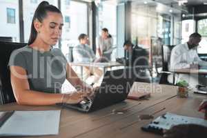 Business woman on a computer at a startup company, working on email. Girl in corporate management at a desk on the internet in tech office or a web designer learning to design a website on a laptop.