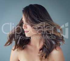 The hair of a goddess. a beautiful young woman posing against a grey background in the studio.