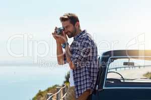 Hes not one to pass up a photo opportunity. a handsome man taking photos while enjoying a road trip.