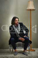 Theres nothing wrong with being old-fashioned. a stylishly dressed man sitting on a chair in the studio.