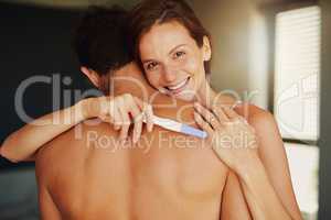 Well be the best parents. Portrait of a happy young woman hugging her boyfriend while holding a pregnancy test.