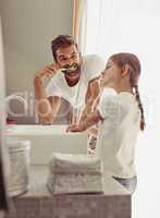 Brushing their way to minty freshness. a happy father and his little girl washing their hands together in the bathroom.