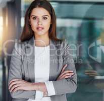Confidence is the key to my success. Portrait of an attractive young businesswoman standing with her arms crossed in the office.