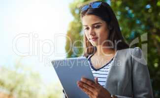 Working while commuting. an attractive young woman using her tablet while commuting to work.