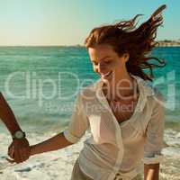 Carefree living is what the seasons all about. a happy young woman running along the beach with her boyfriend.