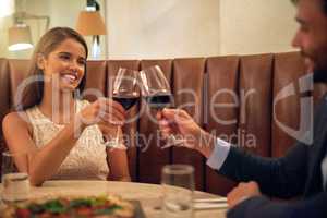 Cheers to more loved filled years. hot of a happy young couple toasting with wine during a romantic dinner date at a restaurant.