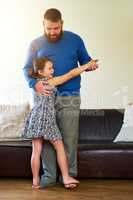 Taking fatherhood step by step. an adorable little girl dancing with her father at home.