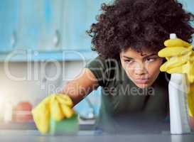 It takes concentration to remove stains. an attractive young woman with yellow gloves cleaning her home.