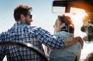 Were living our best lives. Rearview shot of an affectionate couple taking in the sights while enjoying a road trip.