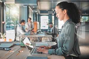 Relax, calm and serious business woman typing, writing and replying on a laptop working on a growth proposal in office. African American female employee writing and planning at a marketing agency