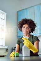 Im almost done. an attractive young woman with yellow gloves cleaning her home.