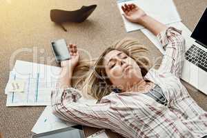 There are just too many demands to keep up with. High angle shot of a stressed out businesswoman lying on the floor in an office.