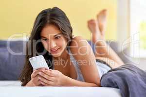 Guess who I had a dream about last night...a beautiful young woman using a mobile phone on her bed at home.
