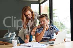 Crunching some numbers. a young couple working on their household budget and paying bills online.