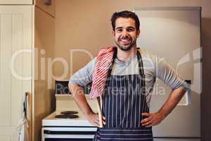 Happiness is homemade. Portrait of a happy young man wearing an apron while standing in his kitchen at home.