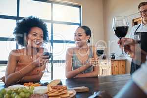 Happy, smile and friends drinking wine and eating healthy, fresh and organic meal with toasted bread on a food table together. Diversity, glass, and relaxed people laughing at a luxury dining party