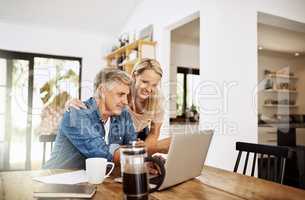 Couple with laptop planning finance, banking and checking retirement budget while becoming debt free at home. Smiling, happy and cheerful mature man showing woman an approved bank loan on technology
