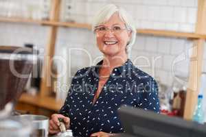I started my own business with my pension annuity. Portrait of a senior woman working in a coffee shop.
