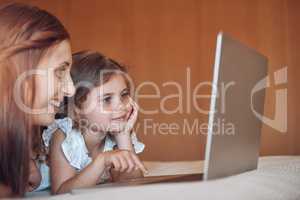 Using the internet safely under Moms supervision. a mother and her little daughter using a laptop together at home.