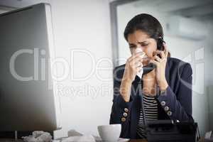 Keep strong and beat this cold. a young businesswoman making a call while blowing her nose and working in the office.