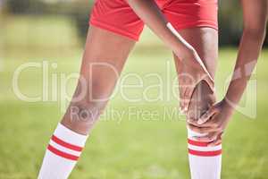 Football knee pain injury of a player hand and leg on a field with closeup for health insurance or anatomy background. Below of soccer or sport athlete with broken bone emergency or sports accident