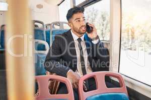 Businessman consulting on a phone call on a bus in the morning travel to work in the city. Entrepreneur, employee and worker speaking to a contact on a mobile cellphone in public transportation
