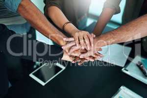 Anything is possible if we work hard together. Closeup shot of a group of businesspeople joining their hands together in unity.