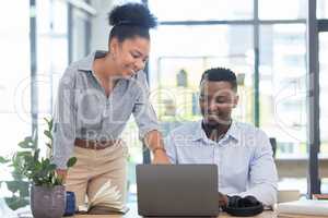 Marketing workers working on a laptop at a office desk in a planning meeting at a startup business. Manager, leader or mentor coaching employee and showing support, collaboration and teamwork at work