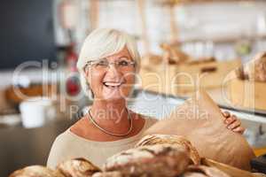 We only serve it fresh. Portrait of a happy senior woman working in a bakery.
