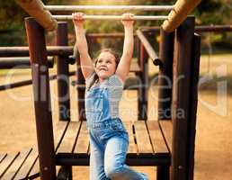 Playing is a childs favourite way of learning. a little girl playing on the jungle gym at the park.