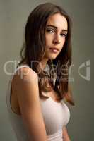 Theres beauty in simplicity. Studio portrait of an attractive young woman standing against a brown background.