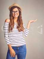 This totally deserves a second look. Studio portrait of an attractive young woman presenting your copy space against a gray background.