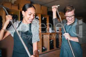 Winemaker workers in wine production using press tool for mixing or pressing in a warehouse, winery or distillery. Teamwork people, woman and man working on quality alcohol, manual labor in a cellar