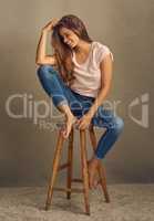 Because no one is worth your tears. Studio shot of a beautiful young woman sitting on a stool against a plain background.