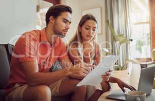 Anxiety, debt and stress with a couple paying bills on a laptop, checking their budget and savings. Young husband and wife looking worried while reading a loan application or contract together