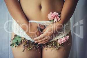 Femininity in full bloom. High angle shot of an unidentifiable young woman with flowers growing out of her lace panties.