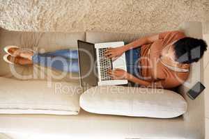 Blogging at home in the most comfy way. an unrecognizable woman using a laptop at home.